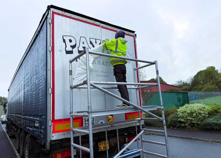 Installing the large graphics with the assistance of a scaffold tower