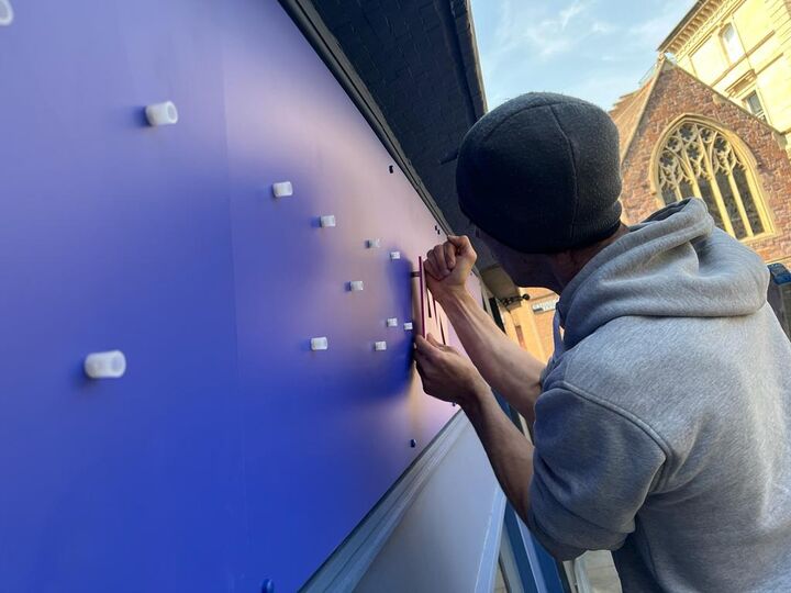 applying stand off locators for acrylic lettering on fascia panel - the cheeky vegan.jpg