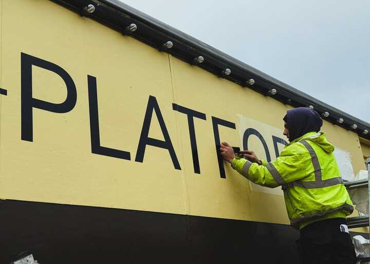 Applying large vinyl graphics to the train carriage